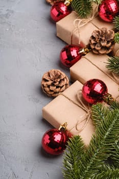 Christmas holidays composition. Red ornament and bauble decorations, fir-tree, gifts and pine cones. Copy space