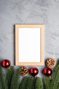 Christmas holidays composition with picture frame mockup. Red baubles and fir-tree branches.