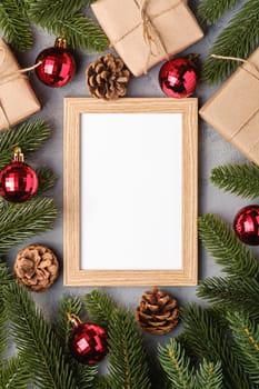 Christmas holidays composition with picture frame mockup. Red baubles, gifts and fir-tree branches.