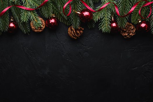 Christmas holidays composition. Red ribbon, ornament and bauble decorations, fir-tree and pine cones. Copy space