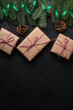 Christmas holidays composition. Green ribbon and giftbox wrapping, fir-tree, pine cones. Copy space