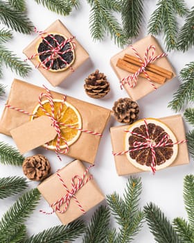 Christmas holidays zero waste paper gifts wrapping with tag, dried fruit and fir branches