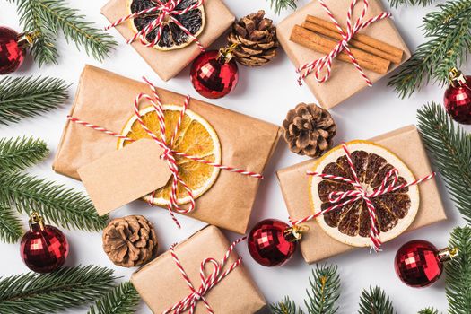 Christmas holidays zero waste paper gifts wrapping with tag, baubles, dried fruit and fir branches