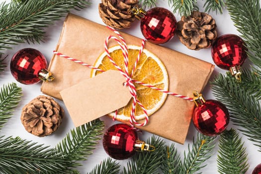 Christmas holidays zero waste paper gift wrapping with tag, baubles, dried fruit and fir branches