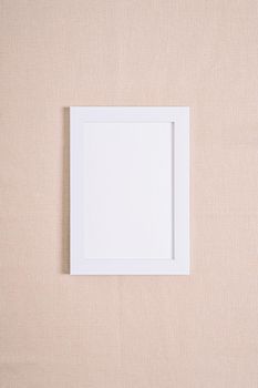 White picture frame mockup on a beige textile
