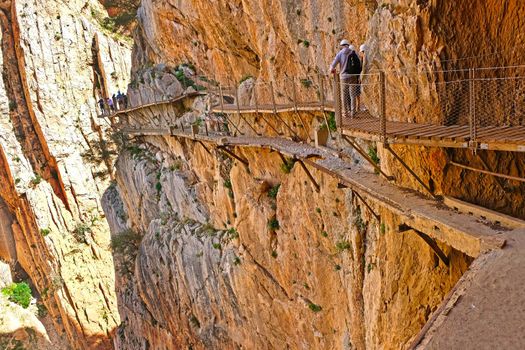 People walking over a suspended track of the Caminito del Rey gorge in Spain
