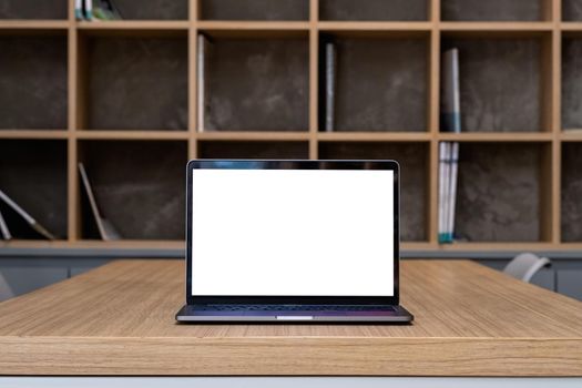 Laptop with blank screen on table in library room.