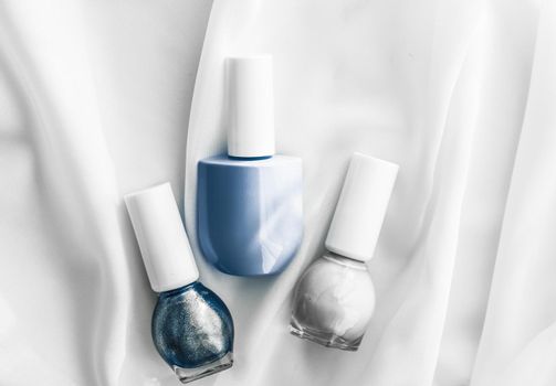 Cosmetic branding, salon and glamour concept - Nail polish bottles on silk background, french manicure products and nailpolish make-up cosmetics for luxury beauty brand and holiday flatlay art design