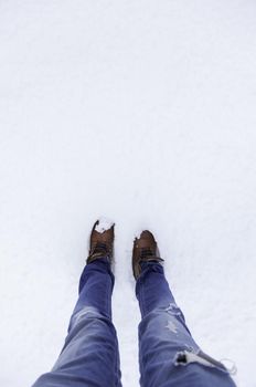 Detail of men's boots on a snowy day in winter, cold and ice