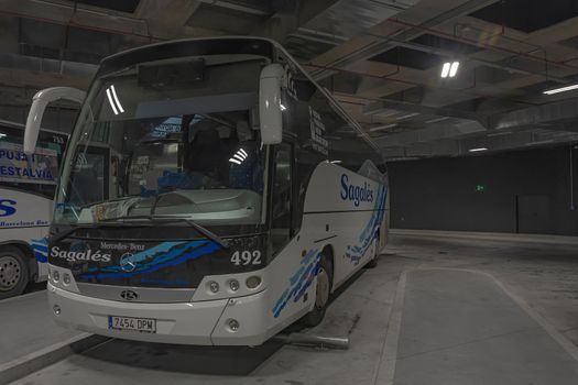 Girona, Spain - April 03, 2021: Intercity bus of the Spanish transport company at the underground stop of the city bus station. Stock photo.