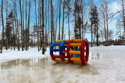 Two large multi-colored plastic wheels in the amusement park. The Cloak of Entertainment in early spring