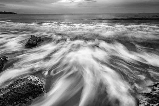 Stunning black and white long exposure seascape at cloudy day.