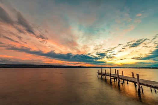 Idyllic sunset at the seashore with a wooden pier. Time for relaxing