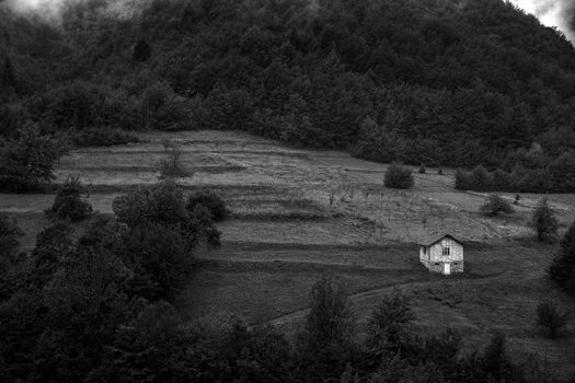 Alone old house on a hill in a mountain. Black and white