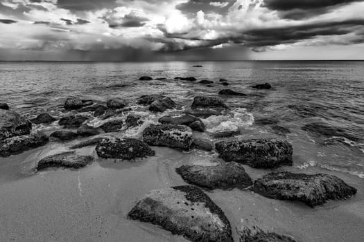 A stunning cloudy day view with the rocky sea coast in black and white