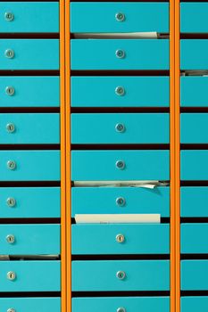 A group of blue metallic mailboxes with round locks