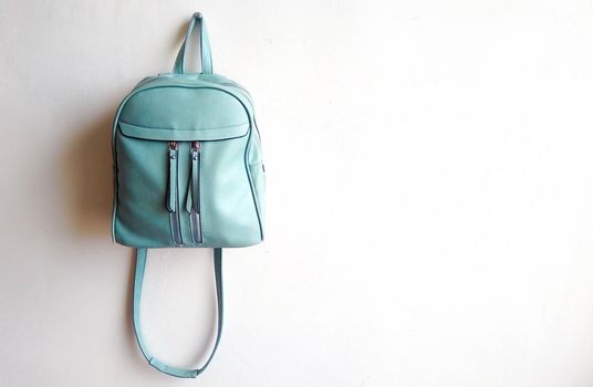 Leather blue women's small backpack with straps on a white background.Space for text.