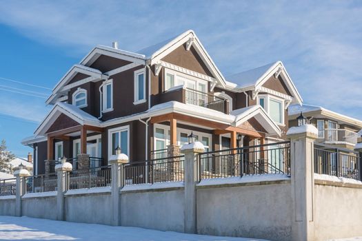 Luxurious residential house with front yard in snow. North American family house on winter sunny day