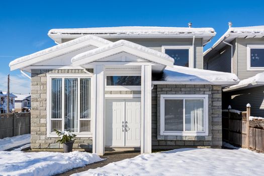 A typical american house in winter. Snow covered. Nice residential house in snow on winter season in Canada