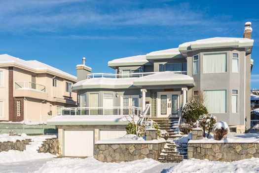 Big luxury residential house in winter season. North American family house on winter sunny day