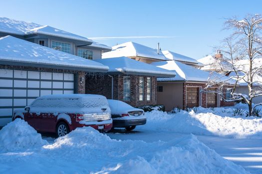 Residential driveway and front yard of houses in snow on winter season