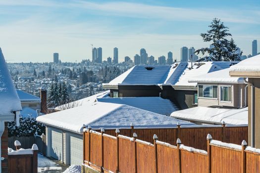 Residential driveway with cityscape on horizon in winter time. Cityscape on bright sunny winter day in Canada