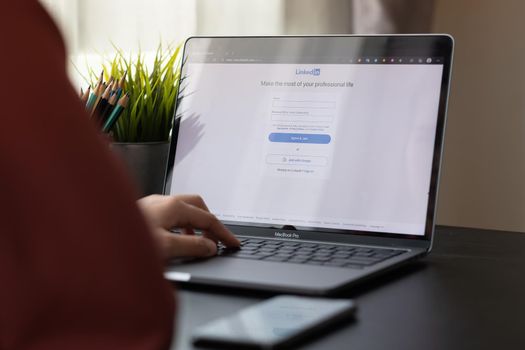 CHIANG MAI, THAILAND, APR 10, 2021 : A woman using macbook pro with LinkedIn on the screen.LinkedIn is a photo-sharing web.