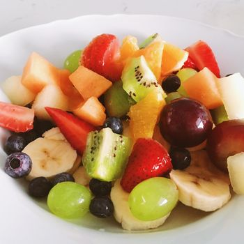 Fresh fruit salad as healthy nutrition and natural diet concept, mixed organic fruits in a bowl.