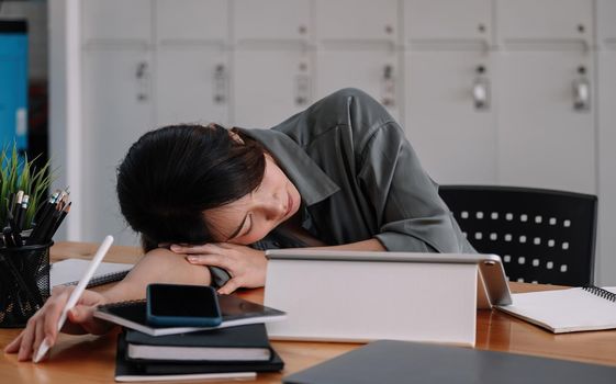 Overworked tired businesswoman sleeping on table in office. Young exhausted girl working from home. Woman using laptop. Entrepreneur, business, freelance work, student, stress, work from home concept