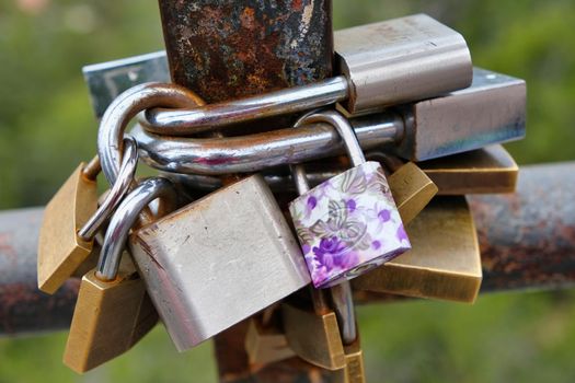 Love Commitment padlocks in a rusty fence