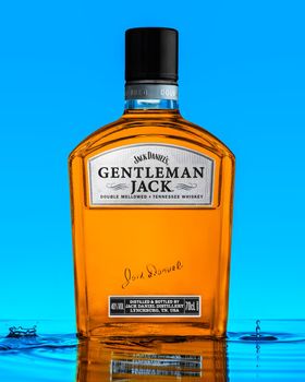 Hamburg Germany, April 01, 2021. American Whiskey Jack Daniel's Gentleman Jack with water drop or splash on blue Background.