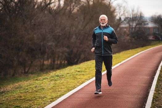 Active senior man is jogging. Healthy retirement lifestyle.