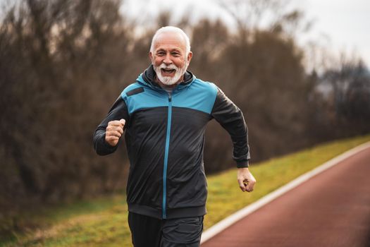 Active senior man is jogging. Healthy retirement lifestyle.