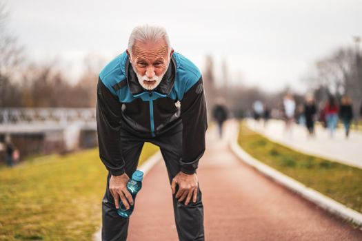 Active senior man is exhausted after exercising. Healthy retirement lifestyle.