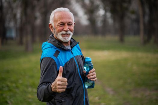 Happy senior man is ready for exercising in park.