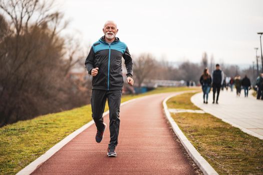 Active senior man is jogging. Healthy retirement lifestyle.