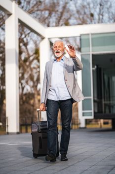Happy senior businessman is arriving from business trip.