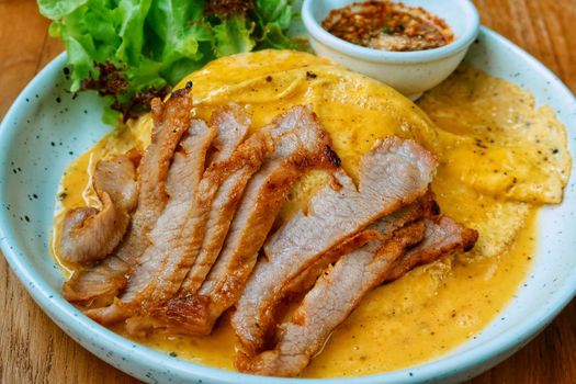 top view of grilled pork neck with omelette and spicy sauce