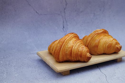 Closeup butter classic croissant on wood plate