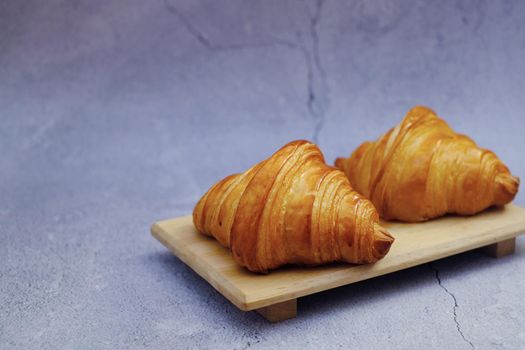 Closeup butter classic croissant on wood plate