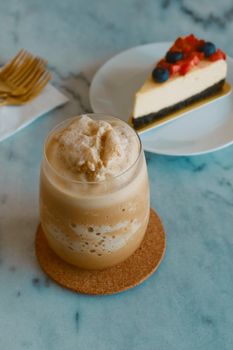 iced frappe salted caramel coffee  with berry cheesecake background