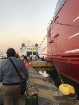 Unidentified crowd with luggage queue in the sea port of Piraeus, prior to departure to the Cycladic islands.