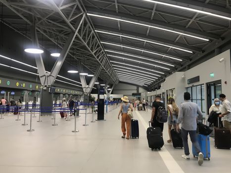 People with face protection at new terminal of International Airport Macedonia.