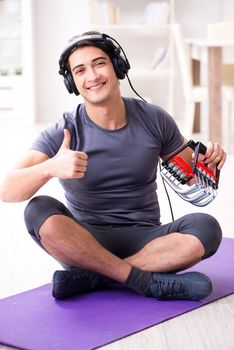 Man doing sports with resistance band and listening to music