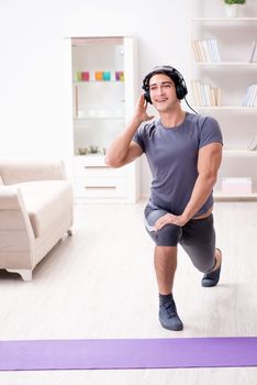 Man doing sports at home and listening to music