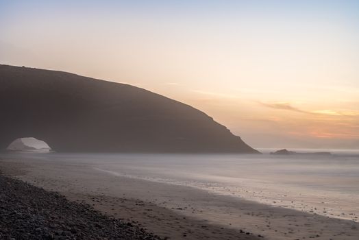 Landscape of Legzira Beach with its natural arches at the coast of Atlantic ocean. Legzira Beach is located on the ocean coast of Morocco, in Sidi Ifni, close to Agadir.