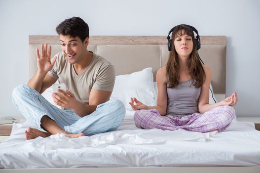 Young family meditating in the bed bedroom