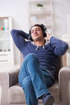 Young man listening to music at home