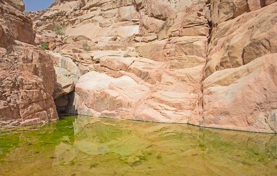 Freshwater pool under overhang in desert mountain canyon