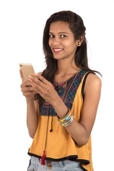 Portrait of a happy young girl using mobile phone isolated over white background